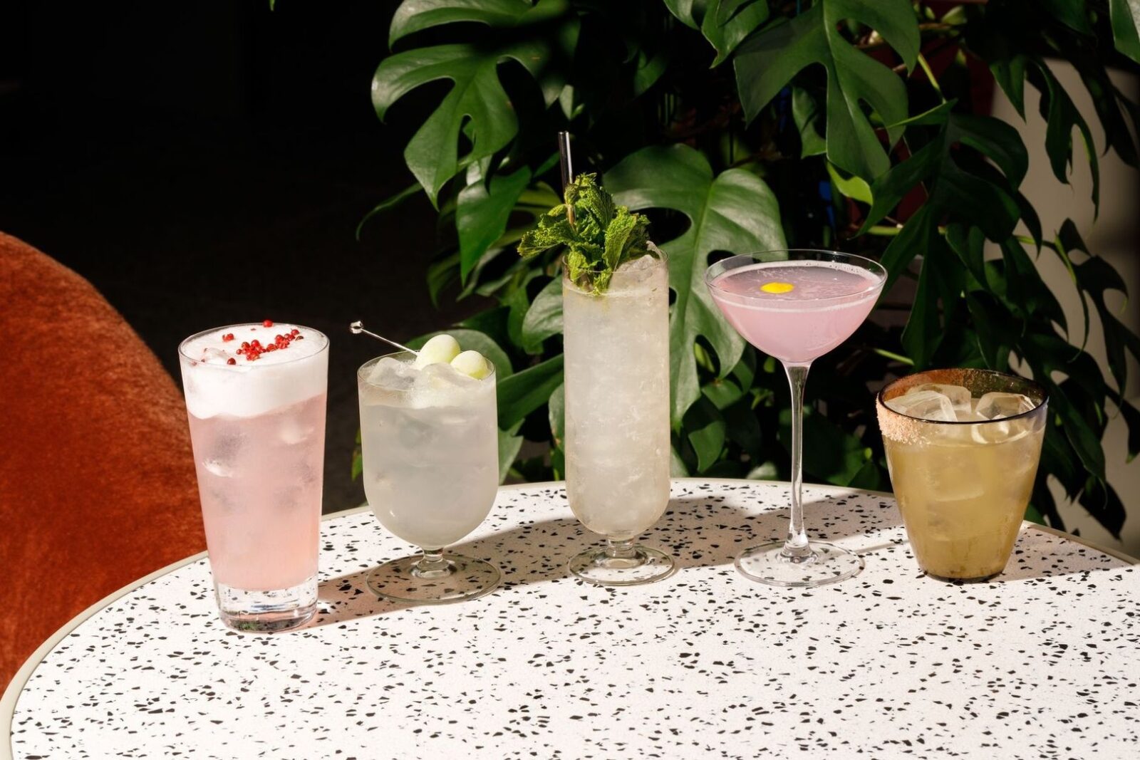 Fem färgstarka alkoholfria drinkar med örter, bär och citrus på ett bord